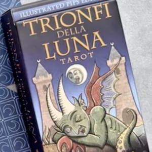 May include: A tarot card box with the title "TRIONFI DELLA LUNA TAROT" in gold lettering on a dark blue background. The box features illustrations of a sleeping creature, towers, and a crescent moon. The author's name, Patrick Valenza, is printed at the bottom.