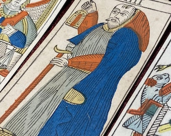 May include: A vintage tarot card with the number VIII in the top right corner. The card depicts a man in a blue robe holding a sword. The card is worn and has a yellowed background.