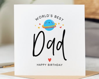 May include: A white card with the text "World's Best Dad" in black script. A blue planet with a yellow ring and a smiling face is above the text. There are red hearts and yellow stars around the planet. The text "Happy Birthday" is below the main text.