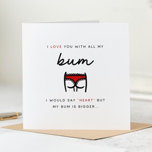 May include: A white greeting card with the text "I LOVE YOU WITH ALL MY bum" and "I WOULD SAY HEART BUT MY BUM IS BIGGER..." in black and red. A cartoon of red underwear is below the word "bum".