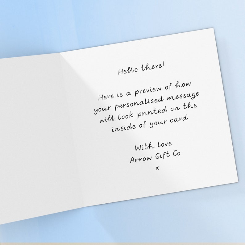 May include: A white card with a handwritten message that says "Hello there! Here is a preview of how your personalized message will look printed on the inside of your card. With love, Arrow Gift Co. X"
