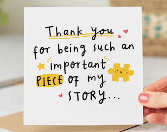 May include: A white card with black handwritten text that reads "Thank you for being such an important piece of my story..." with a yellow puzzle piece with a smiley face and red hearts.