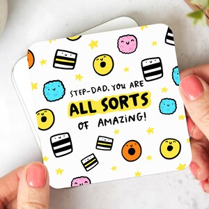 May include: White coaster with a colourful cartoon design featuring sweets and stars. The text reads "Step-Dad, you are all sorts of amazing!"