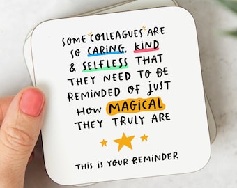 May include: White coaster with black text that reads "Some colleagues are so caring, kind & selfless that they need to be reminded of just how magical they truly are. This is your reminder." The text is in a handwritten style with colorful underlines. There are three yellow stars at the bottom.