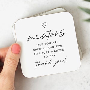 May include: White square coasters with rounded corners. The coasters have black text that reads "mentors LIKE YOU ARE SPECIAL AND FEW. SO I JUST WANTED TO SAY Thank you!" with a heart symbol above the word "mentors".