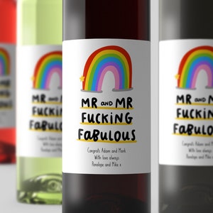 Puede incluir: Dos botellas de vino con etiquetas de arco&iacute;ris que dicen "Mr and Mr Fucking Fabulous". Las etiquetas tambi&eacute;n incluyen el texto "Congrats Adam and Mark, With love always, Penelope and Mike x".