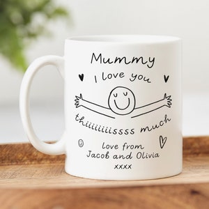 May include: White ceramic mug with a black handwritten message that reads "Mummy I love you this much love from Jacob and Olivia XXXX" with a simple drawing of a person with arms outstretched.