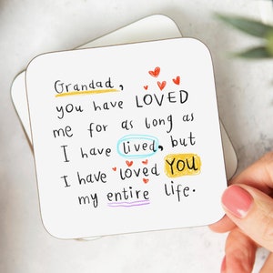 May include: A white card with a handwritten message that reads "Grandad, you have LOVED me for as long as I have lived, but I have loved You my entire life." The message is written in black marker with colourful accents. There are several red hearts drawn around the message.