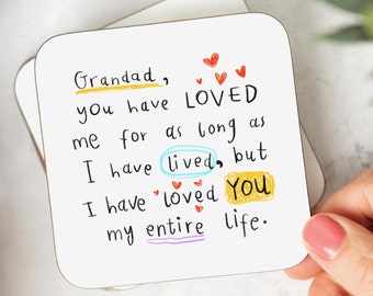 May include: A white card with a handwritten message that reads "Grandad, you have LOVED me for as long as I have lived, but I have loved You my entire life." The message is written in black marker with colorful accents. There are several red hearts drawn around the message.