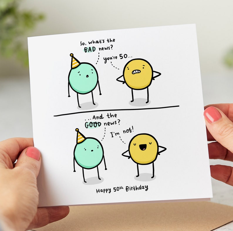 May include: A humorous birthday card with a green circle character wearing a party hat and a yellow circle character. The text reads "So, what's the BAD news? You're 50... And the GOOD news? I'm not! Happy 50th Birthday."