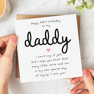 May include: A white card with black text that reads "Happy FIRST birthday as my daddy. I can't say it yet, but I hope you know that every little smile and coo is my own special way of saying "I love you.""