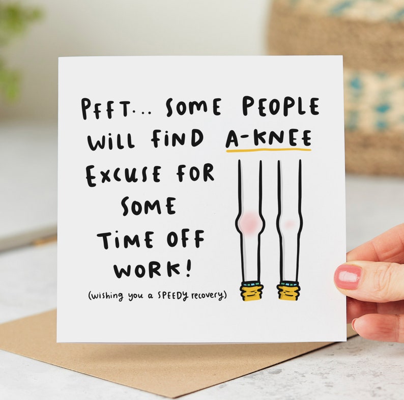 May include: A white card with a humorous get well soon message. The card features a cartoon illustration of two legs with a red knee injury. The text reads "PFFT... SOME PEOPLE WILL FIND A-KNEE EXCUSE FOR SOME TIME OFF WORK! (wishing you a SPEEDY recovery)"