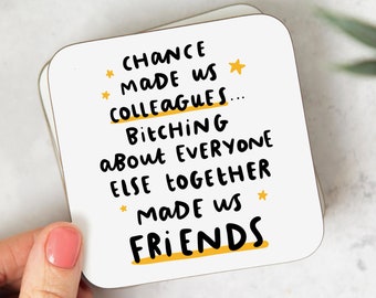 May include: White coaster with black text that reads "Chance made us colleagues... Bitching about everyone else together made us friends". The text is underlined in yellow and there are yellow stars on the coaster.