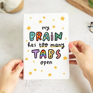 May include: White card with colourful text that reads "my brain has too many tabs open". The text is surrounded by yellow stars.
