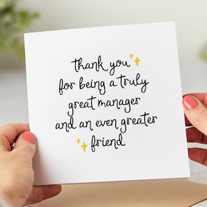 May include: A white card with black text that reads "Thank you for being a truly great manager and an even greater friend." There are two gold stars on the card.