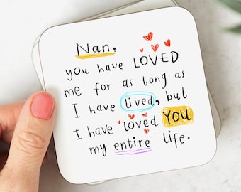 May include: A white coaster with a handwritten message that reads "Nan, you have LOVED me for as long as I have lived, but I have loved You my entire life." The message is written in black, red, yellow, blue, and purple ink. There are small red hearts drawn around the message.