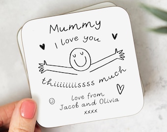 May include: White coaster with black text and a simple drawing of a person with arms outstretched. The text reads "Mummy I love you thiiiiiiiissss much love from Jacob and Olivia xxxx".