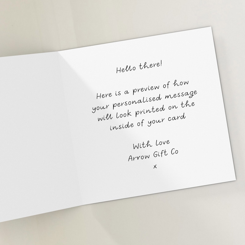 Puede incluir: Una tarjeta blanca con texto negro que dice "Hello there! Here is a preview of how your personalised message will look printed on the inside of your card With Love Arrow Gift Co X".