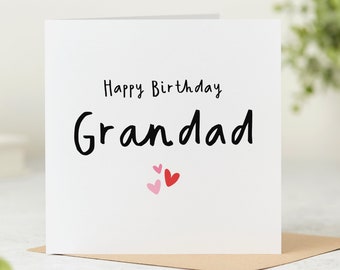 Può includere: Carta bianca con testo nero che dice "Buon compleanno Nonno" con tre cuori rosa e rossi sotto il testo.