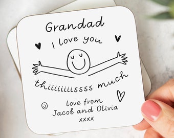 May include: White coaster with black text that reads "Grandad I love you thisssss much love from Jacob and Olivia XXXX" with a simple drawing of a smiling person with outstretched arms.