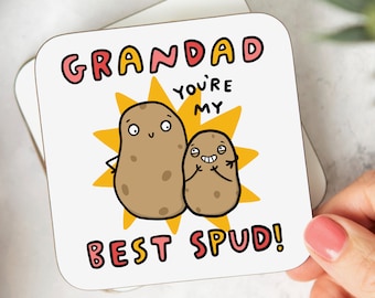 May include: A white coaster with a yellow sunburst design. Two cartoon potatoes with faces are in the center of the sunburst. The text "Grandad you're my best Spud!" is written in colorful letters.