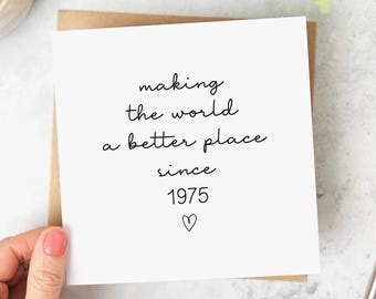 May include: A white card with black text that reads "making the world a better place since 1975" with a small heart symbol at the bottom.