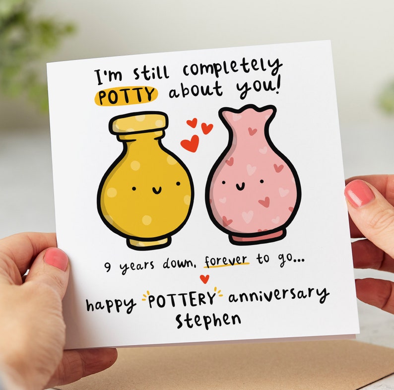 May include: A greeting card with a cute illustration of two pottery pieces, a yellow jar and a pink vase, with hearts around them. The text reads "I'm still completely POTTY about you! 9 years down, forever to go... happy POTTERY anniversary Stephen."