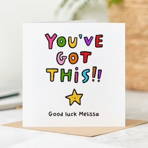 May include: A white card with colourful text that reads "You've Got This!" with a yellow star with a smiley face. The text "Good luck Melissa" is at the bottom of the card.