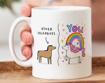 May include: White ceramic mug with a cartoon illustration of a horse and a unicorn. The text "OTHER COLLEAGUES..." is above the horse and "YOU" is above the unicorn. The unicorn is standing on a rainbow with stars and hearts around it.