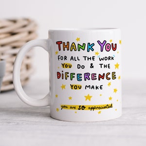 Puede incluir: Taza de café de cerámica blanca con un mensaje colorido que dice "THANK YOU FOR ALL THE WORK YOU DO & THE DIFFERENCE YOU MAKE you are so appreciated" con estrellas amarillas alrededor del texto.