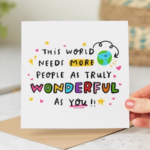May include: A white card with a colourful message that reads "This world needs more people as truly wonderful as you!" The card features a cartoon earth with a smiling face and pink hearts.