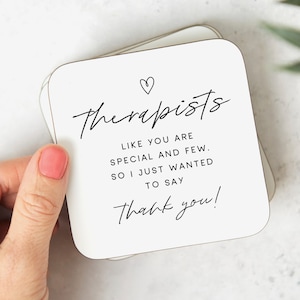 May include: White coaster with black text that reads "Therapists like you are special and few. So I just wanted to say thank you!" with a small heart symbol above the word "Therapists".