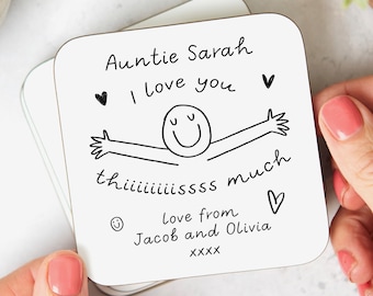 Może przedstawiać: Biały podkładka z czarnym ręcznie pisanym tekstem, który mówi "Auntie Sarah I love you th iiiiiiissss much Love from Jacob and Olivia XXXX" ze śmieszkiem i sercami.