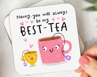 May include: Square coaster with a whimsical design featuring two cartoon teacups, one pink and one yellow, with the text "Nanny, you will always be my BEST-TEA." The pink teacup has hearts and a tea bag. The yellow teacup has polka dots.