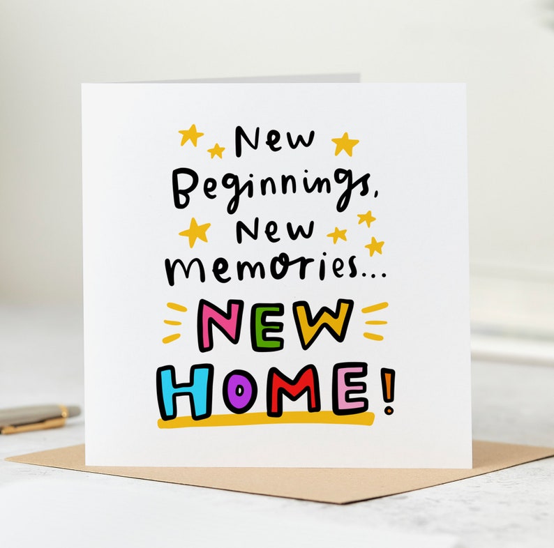 Puede incluir: Una tarjeta blanca con el texto "Nuevos Comienzos, Nuevos Recuerdos... &iexcl;NUEVO HOGAR!" en letras de colores con estrellas amarillas y un subrayado dorado.