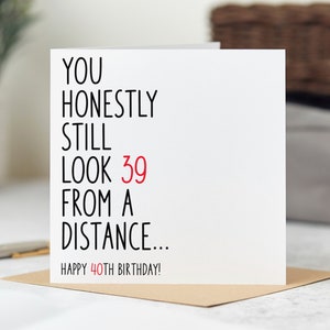 May include: A white card with black text that reads "You honestly still look 39 from a distance... Happy 40th Birthday!"