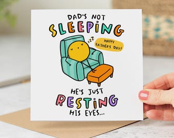 Puede incluir: Una tarjeta del Día del Padre con una ilustración de dibujos animados de un personaje amarillo descansando en un sillón turquesa con un reposapiés naranja. La tarjeta dice "Dad's Not Sleeping, He's Just Resting His Eyes..." y "Happy Father's Day!"