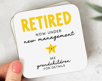 May include: A white coaster with the text "RETIRED NOW UNDER new management" in black. A yellow star with a smiley face is below the text. The text "SEE grandchildren FOR DETAILS" is below the star.