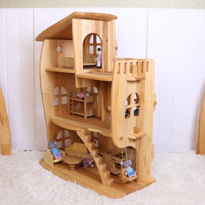 May include: A wooden dollhouse with a whimsical design, featuring multiple levels, windows, and a swing. The dollhouse is made of natural wood and has a light brown finish. The dollhouse is decorated with small wooden figures and furniture.