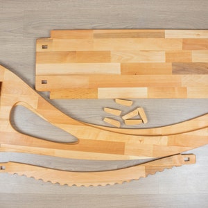 K&ouml;nnte beinhalten: Holzstuhl-Set mit mehreren Teilen, darunter eine gebogene R&uuml;ckenlehne, eine Sitzfl&auml;che und Beine. Das Set enth&auml;lt auch eine rechteckige Holzplatte und mehrere kleine Holzst&uuml;cke.