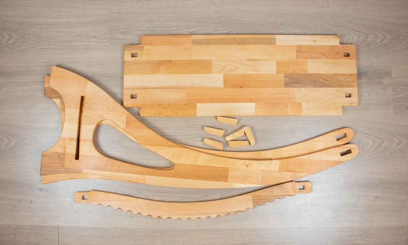 K&ouml;nnte beinhalten: Holzstuhl-Set mit mehreren Teilen, darunter eine gebogene R&uuml;ckenlehne, eine Sitzfl&auml;che und Beine. Das Set enth&auml;lt auch eine rechteckige Holzplatte und mehrere kleine Holzst&uuml;cke.