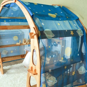 May include: A wooden playhouse with a blue and white star-patterned fabric canopy. The playhouse has shelves and a small play area inside.