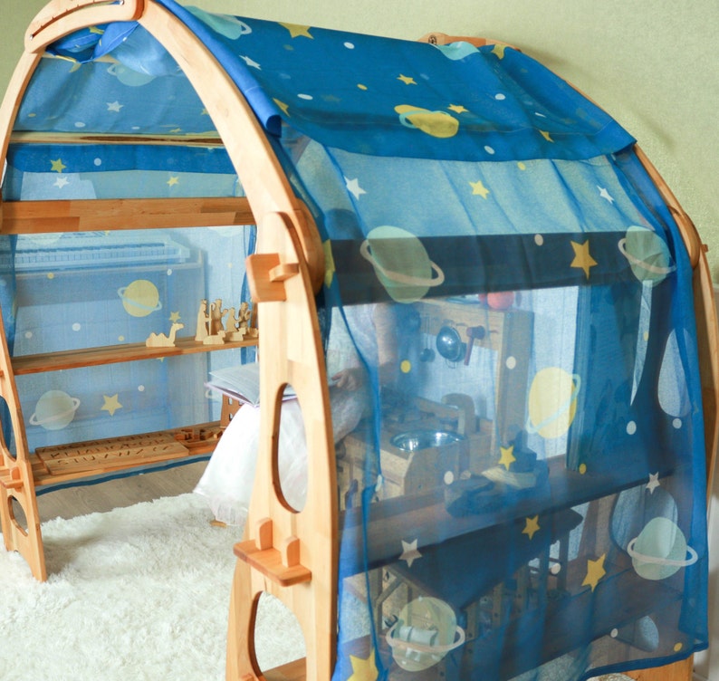 May include: A wooden playhouse with a blue and white star-patterned fabric canopy. The playhouse has shelves and a small play area inside.