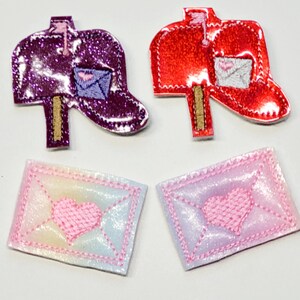 May include: Two red and purple glitter mailbox appliques with a white envelope with a pink heart. Two iridescent pink envelopes with a pink heart.