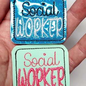 May include: Two iron-on patches with the text "Social Worker" in different colors and styles. The top patch is blue with white text and the bottom patch is green with pink text.