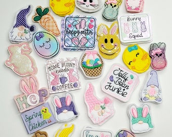 May include: A collection of 20 colorful embroidered iron-on patches featuring Easter-themed designs. The patches include bunnies, chicks, gnomes, eggs, and other spring-themed imagery. Some patches have text, such as "Happy Easter", "Some Bunny Needs Coffee", and "Jelly Bean Junkie".