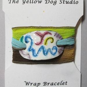 handmade boho silk wrap bracelet with enameled slide on a silk ribbon