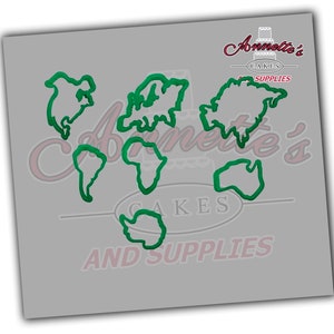 May include: Green plastic cookie cutter shaped like a world map. The cutter is on a gray background with the text "Annette's Cakes and Supplies".