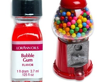 May include: A red and silver gumball machine with a glass jar filled with colorful gumballs. A small bottle of red bubble gum flavoring is next to the gumball machine. The bottle label reads "Lorann Oils Bubble Gum Flavor 1 fl dram 3.7 ml .125 fl oz"