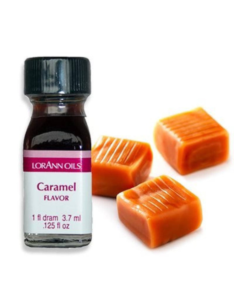 May include: A small brown glass bottle with a black cap. The bottle is labeled "Lorann Oils Caramel Flavor" and contains 1 fl dram (3.7 ml) or .125 fl oz. Three caramel candies are shown in the background.